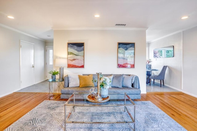 living room with wood-type flooring, crown molding, and plenty of natural light