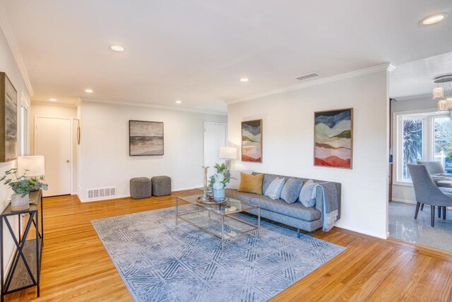 living room with wood-type flooring and crown molding