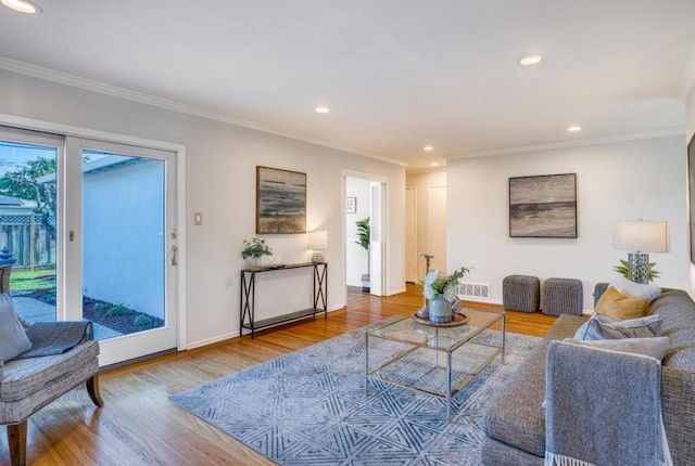 living room with wood-type flooring and ornamental molding