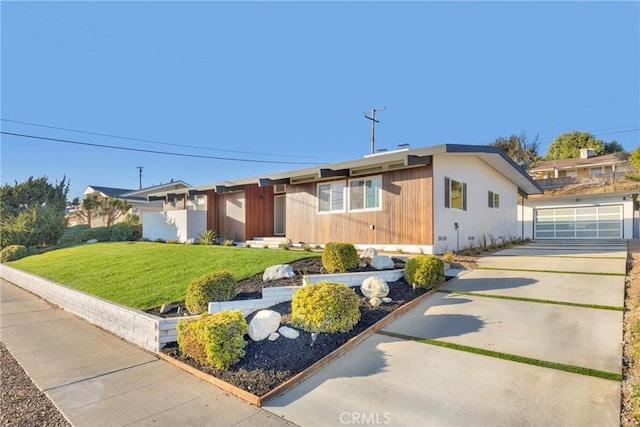 single story home with a front yard, a garage, and an outbuilding