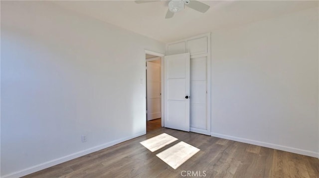 unfurnished bedroom with a closet, ceiling fan, and dark hardwood / wood-style floors