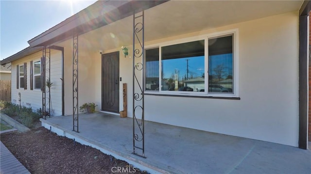 view of exterior entry with a patio area