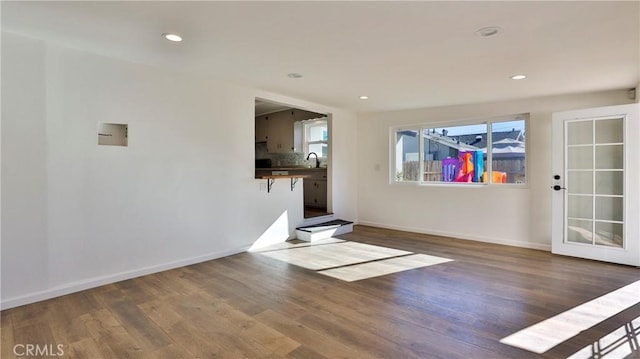 unfurnished living room with sink and dark hardwood / wood-style floors