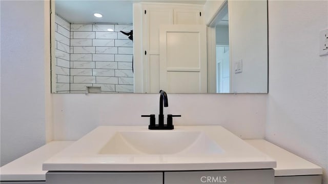 bathroom with vanity and tiled shower