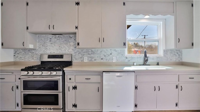 kitchen with white dishwasher, white cabinetry, and range with two ovens