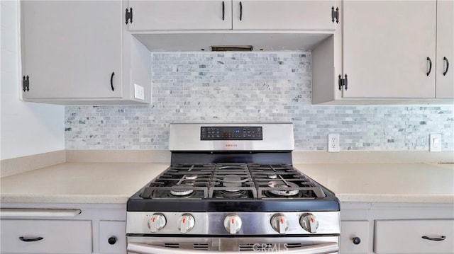 kitchen with white cabinets, stainless steel gas range, and backsplash