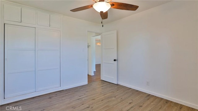 unfurnished bedroom with ceiling fan, light hardwood / wood-style flooring, and a closet