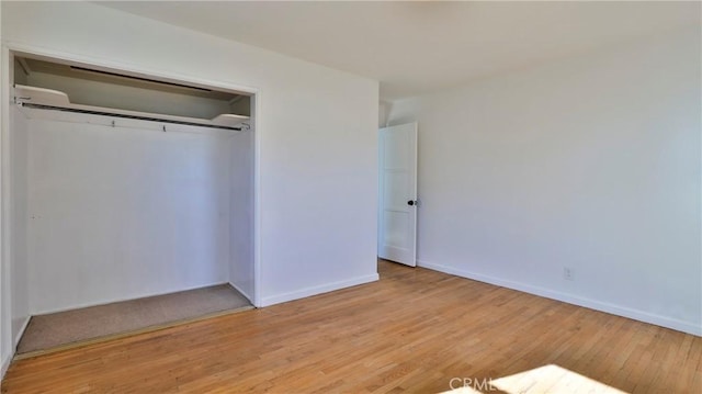 unfurnished bedroom featuring light wood-type flooring and a closet