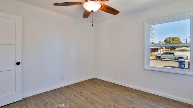 empty room with ceiling fan and light hardwood / wood-style flooring