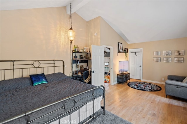 bedroom featuring hardwood / wood-style flooring and vaulted ceiling with beams