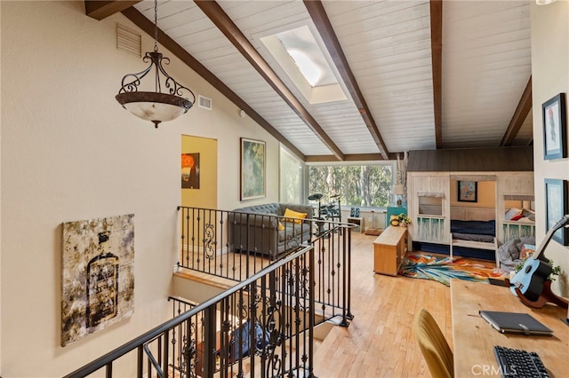 corridor with high vaulted ceiling, a skylight, hardwood / wood-style flooring, and beam ceiling