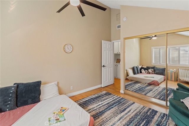 bedroom with vaulted ceiling, ceiling fan, a closet, and light hardwood / wood-style floors