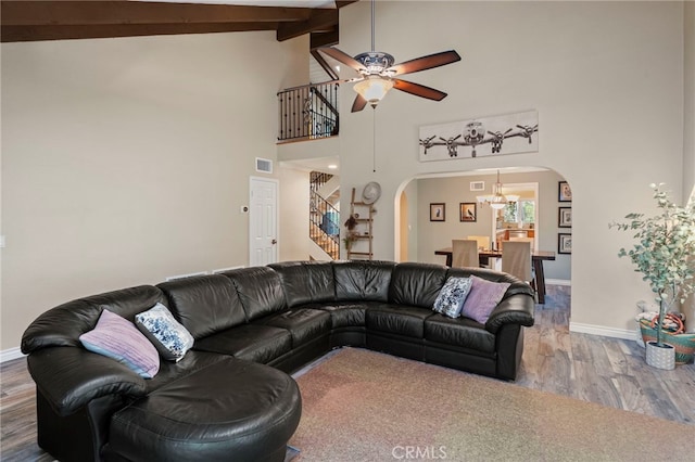 living room featuring ceiling fan with notable chandelier, high vaulted ceiling, beamed ceiling, and hardwood / wood-style flooring