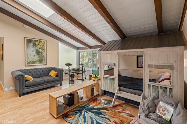 bedroom featuring hardwood / wood-style floors and vaulted ceiling with skylight