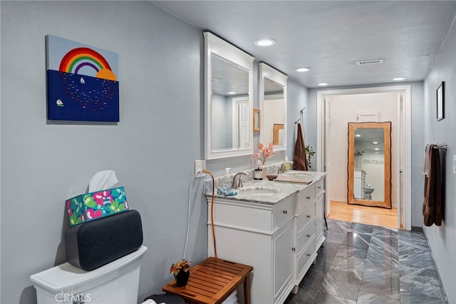 bathroom featuring toilet and vanity