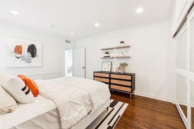 bedroom with dark hardwood / wood-style flooring, a closet, and ornamental molding