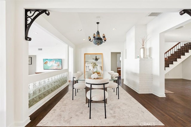 dining room featuring an inviting chandelier, vaulted ceiling, and dark hardwood / wood-style flooring