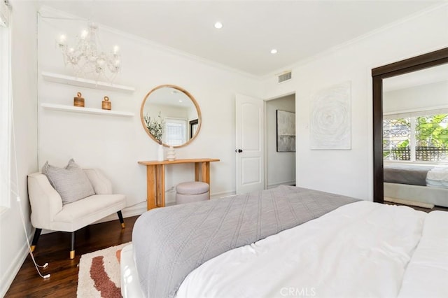 bedroom featuring an inviting chandelier, crown molding, and dark hardwood / wood-style floors