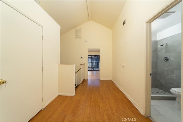 corridor featuring light hardwood / wood-style flooring and vaulted ceiling