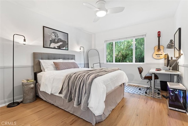 bedroom with light wood-style flooring, baseboards, and a ceiling fan