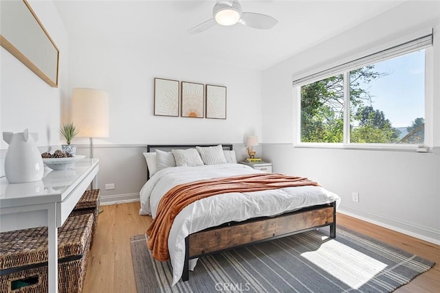 bedroom featuring baseboards, ceiling fan, and light wood finished floors