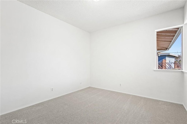 carpeted spare room featuring a textured ceiling