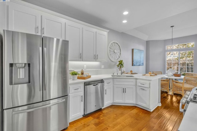 kitchen featuring appliances with stainless steel finishes, white cabinets, sink, and kitchen peninsula