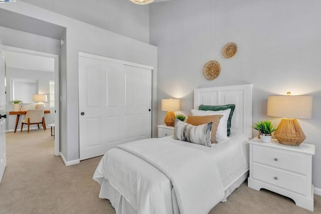 bedroom featuring light colored carpet and a closet