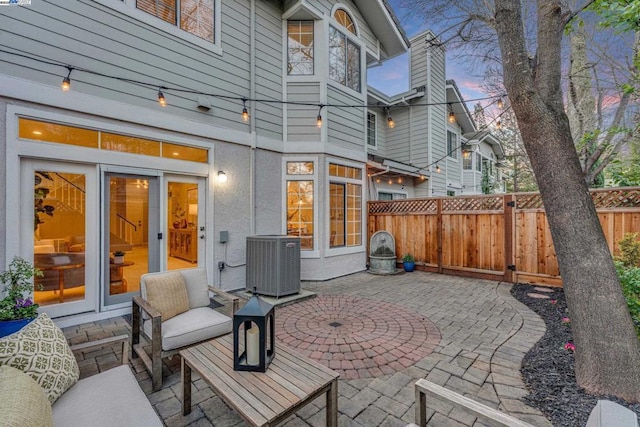 patio terrace at dusk featuring central AC unit