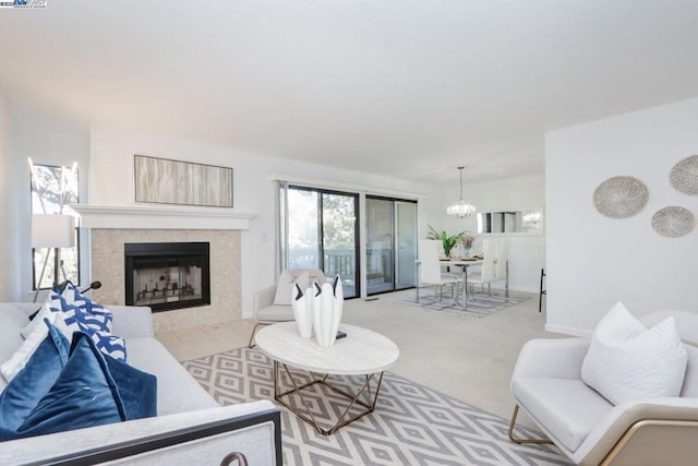 carpeted living room featuring a fireplace and a chandelier