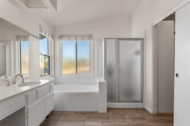 bathroom with hardwood / wood-style flooring, vaulted ceiling, and separate shower and tub