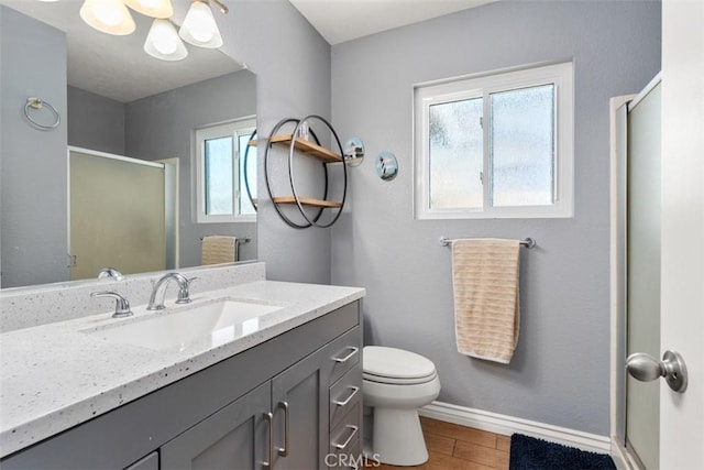 bathroom featuring toilet, an enclosed shower, and vanity