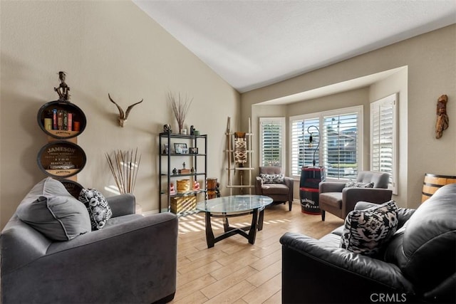 living room with light wood-type flooring and vaulted ceiling