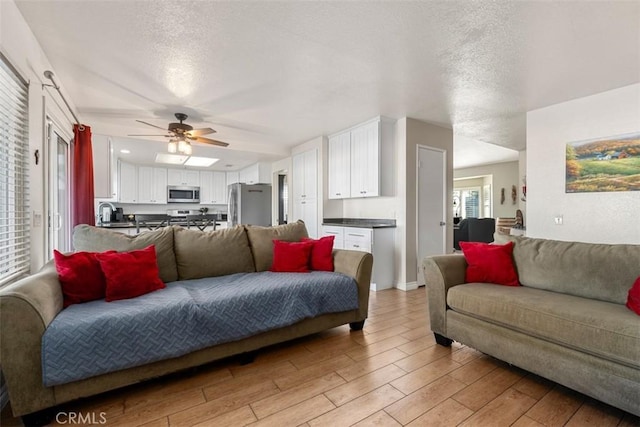 living room with a textured ceiling and ceiling fan