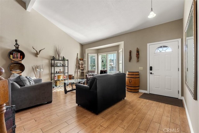 living room featuring light hardwood / wood-style flooring and vaulted ceiling with beams