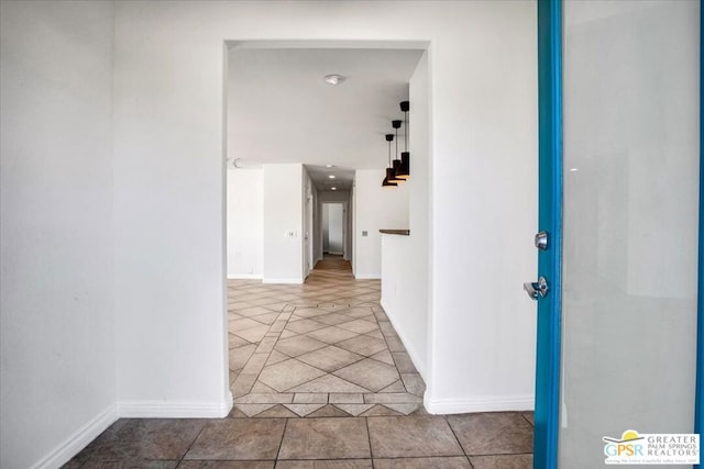 hall with tile patterned floors