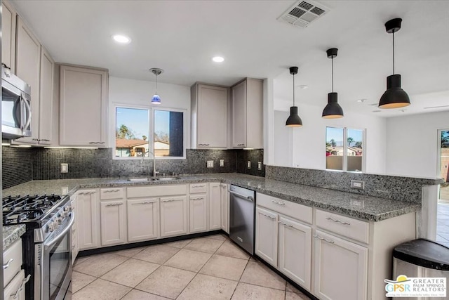 kitchen featuring sink, stainless steel appliances, light tile patterned floors, decorative backsplash, and hanging light fixtures