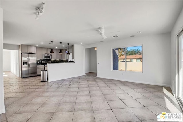 unfurnished living room featuring ceiling fan and light tile patterned floors