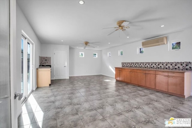 kitchen featuring ceiling fan, sink, and an AC wall unit