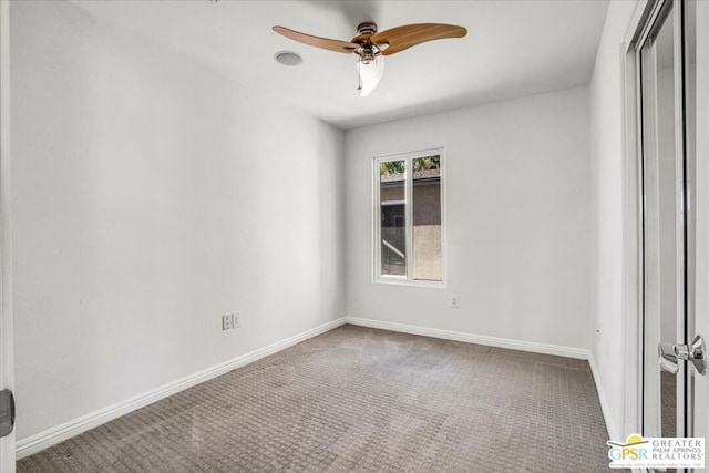 empty room featuring ceiling fan and carpet