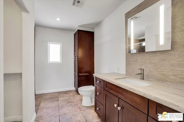 bathroom with toilet, a shower with door, vanity, and backsplash