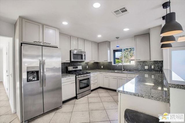 kitchen with decorative light fixtures, appliances with stainless steel finishes, and backsplash