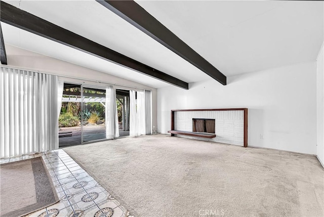 unfurnished living room with vaulted ceiling with beams, a fireplace, and carpet flooring