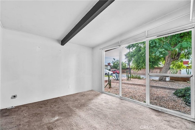 carpeted empty room with beamed ceiling