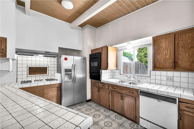 kitchen with white appliances, wood ceiling, tasteful backsplash, sink, and tile countertops