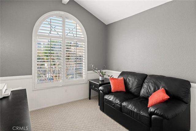 sitting room with light colored carpet and vaulted ceiling with beams