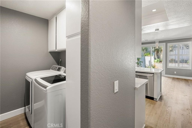 laundry room with cabinets, light wood-type flooring, and independent washer and dryer