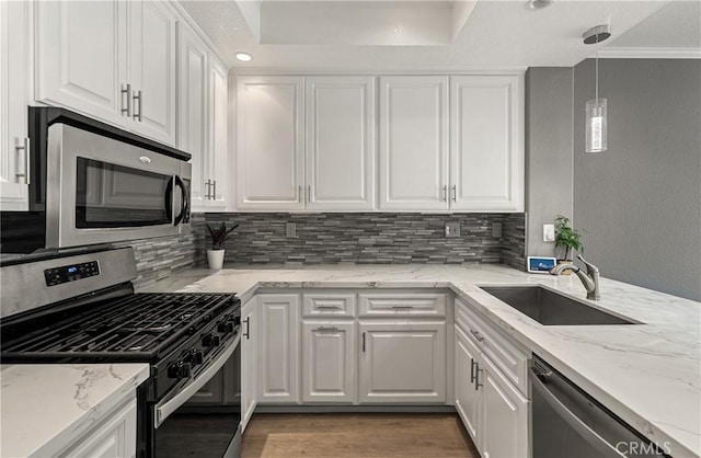 kitchen featuring sink, white cabinets, hanging light fixtures, light stone countertops, and appliances with stainless steel finishes