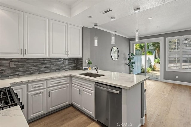 kitchen with kitchen peninsula, dishwasher, pendant lighting, white cabinetry, and sink