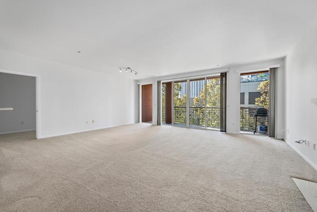 unfurnished living room with track lighting and carpet flooring